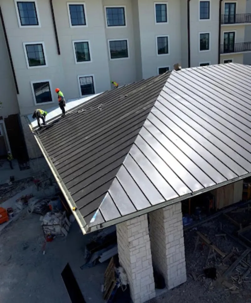 Crew installing standing seam metal roof panels on a commercial project in La Habra